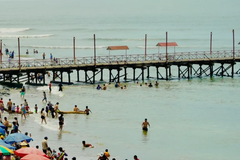 Píer e banhistas na praia de Huanchaco perto de Trujillo
