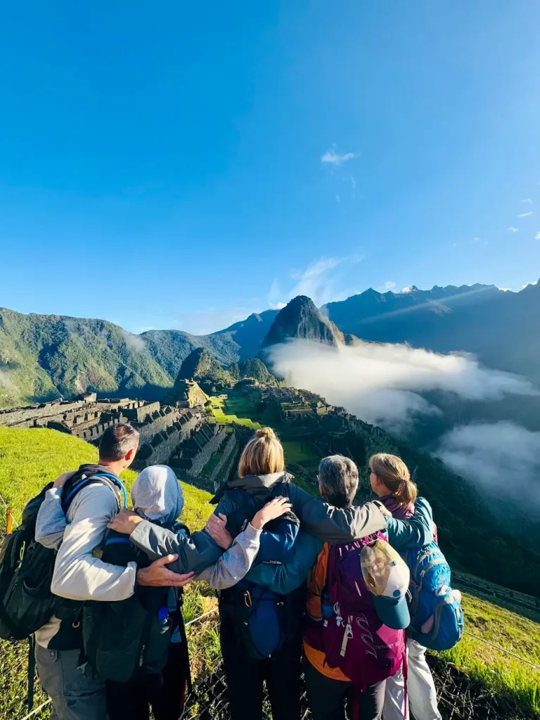 Travelers overlooking Machu Picchu at sunrise on a group tour