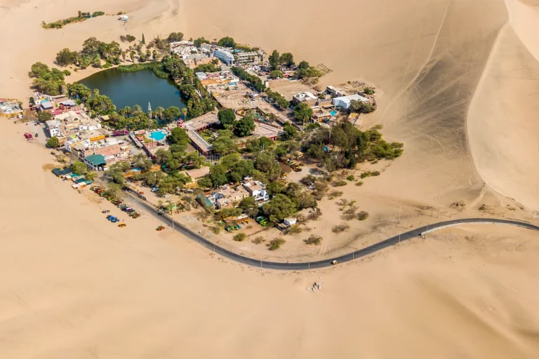 Vista aérea do oásis de Huacachina cercado pelas dunas de Ica